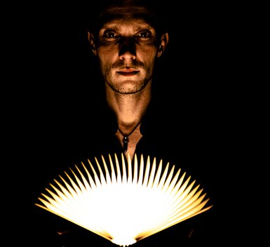 Marco Thomsen med mystisk bog og lys - promofoto illusionist Danmark